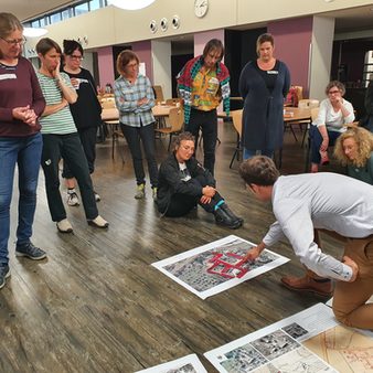 Besprechung in großer Runde anhand eines Modells