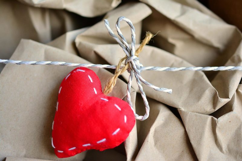 Packpapier, Paketschnur und ein rotes Herz aus Stoff.
