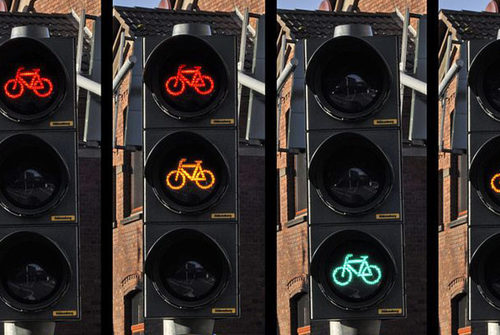 Eine Ampelanlage für Fahrräder, leuchten in rot, gelb und grün.