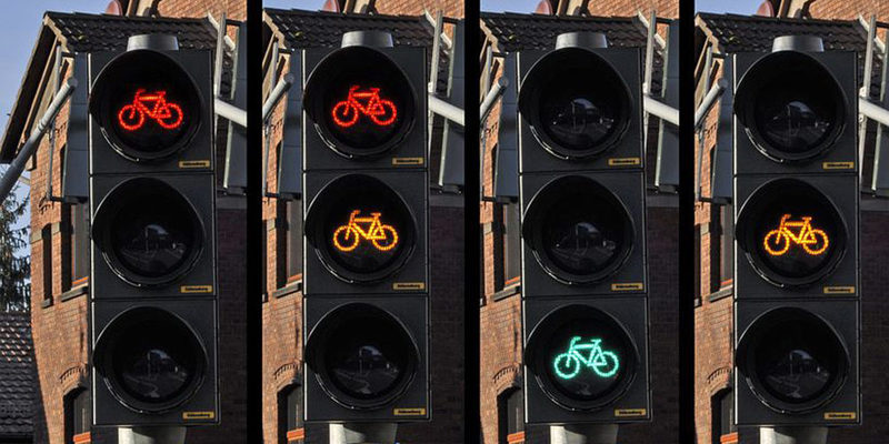 Eine Ampelanlage für Fahrräder, leuchten in rot, gelb und grün.