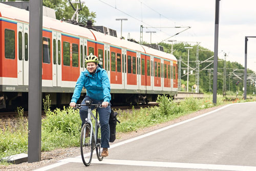 Raddirektverbindung Rüdesheim - Wiesbaden - Radfahrer parallel zu Gleisen und Zug.