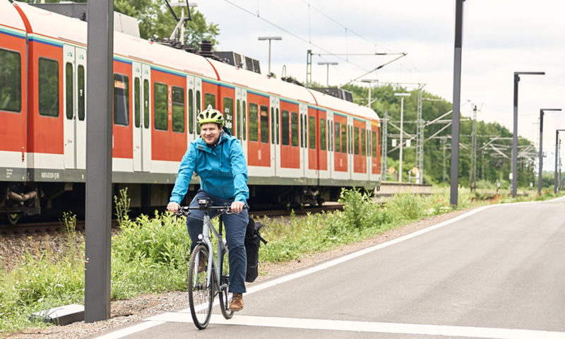 Raddirektverbindung Rüdesheim - Wiesbaden - Radfahrer parallel zu Gleisen und Zug.