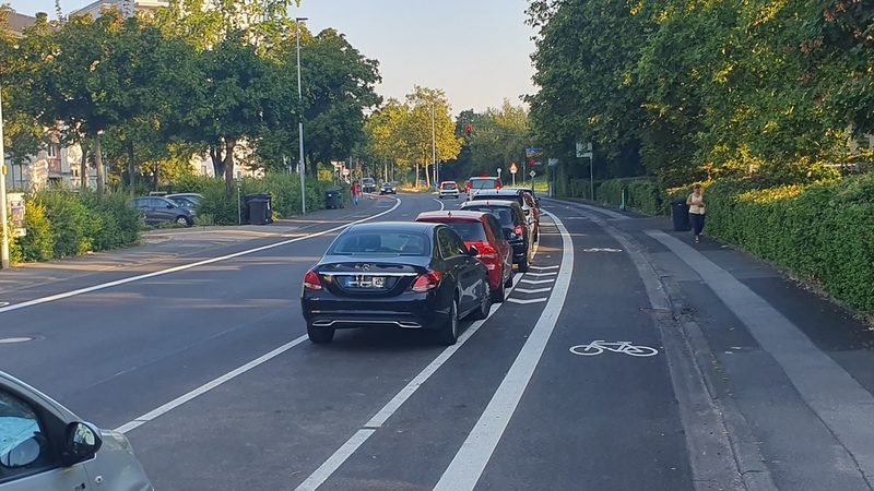 Parkende Autos neben dem Radweg