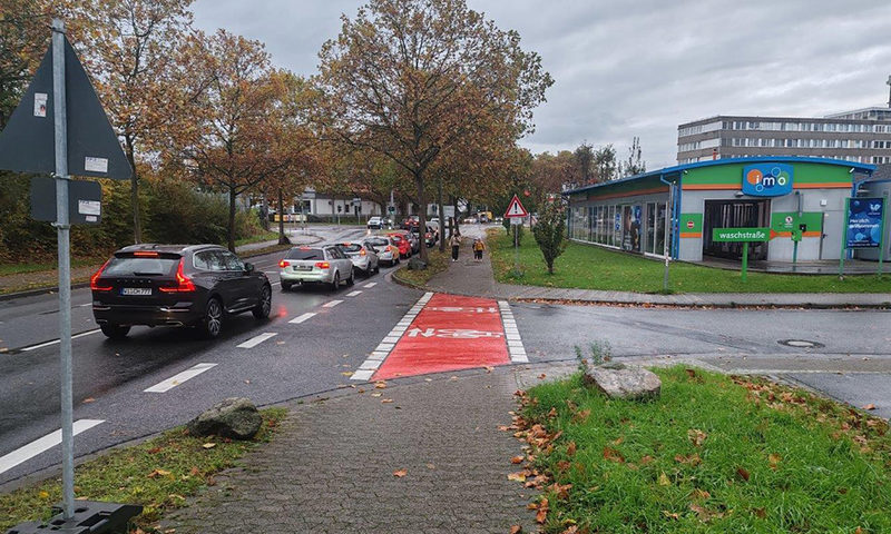 Eine Straße mit Autos und roten Radweg