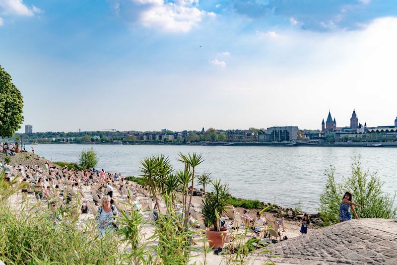 Bastion von Schoenborn am Rheinufer mit Blick nach Mainz und zahlreichen Menschen in Liegestühlen